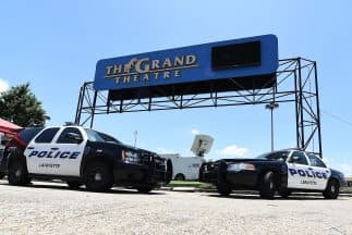 Dos patrullas de la policía de Lafayette, Luisiana, vigilan la entrada del Grand Treatre donde el jueves un pistolero mató a dos personas, hirió a otras nueve y luego se suicidó.