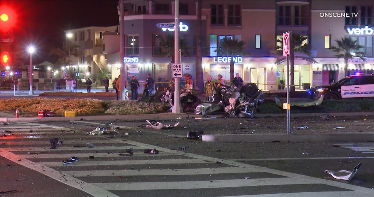 Los bomberos y policías de Newport Beach revisan con detenimiento el área buscando piezas del vehículo dispersas tras el impacto.