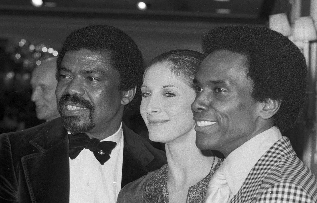 De izquierda a derecha: Alvin Ailey; 
<a href="https://es.wikipedia.org/wiki/Cynthia_Gregory#:~:text=Cynthia%20Kathleen%20Gregory%20(Los%20%C3%81ngeles,y%20famosa%20bailarina%20cl%C3%A1sica%20estadounidense." target="_blank">Cynthia Gregory</a>, del American Ballet Theater; y 
<a href="https://es.wikipedia.org/wiki/Arthur_Mitchell" target="_blank">Arthur Mitchell</a>, del Harlem Dance Theater. La foto fue tomada en Nueva York el 28 de abril de 1975.