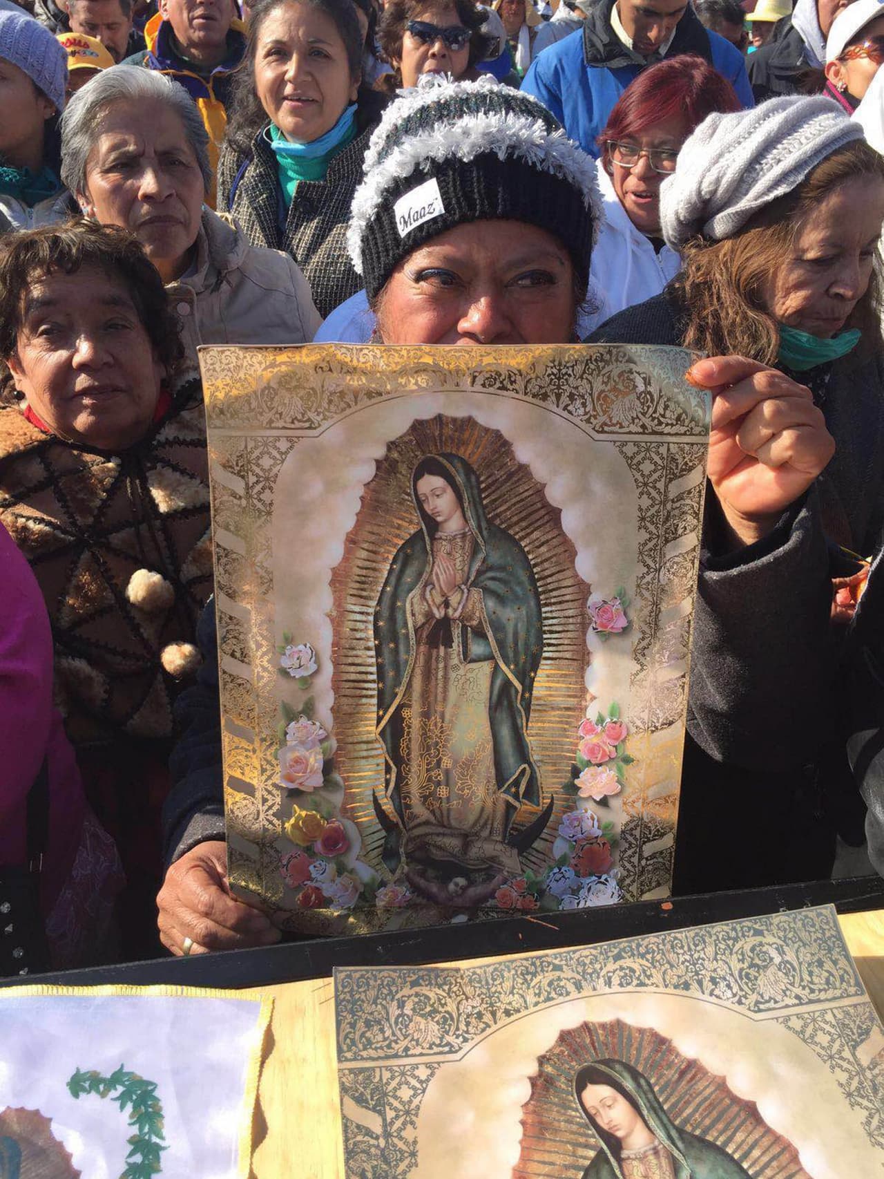Esta mujer sostiene una imagen de la Virgen de Guadalupe al paso del convoy del papa Francisco.