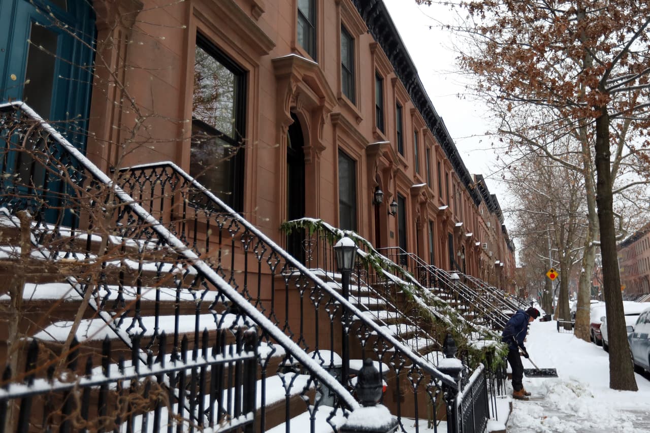 Esta tormenta de finales de otoño ha llegado a Nueva York, donde se han visto las primeras nevadas de la temporada. En la imagen, un hombre limpia la acera en una calle.