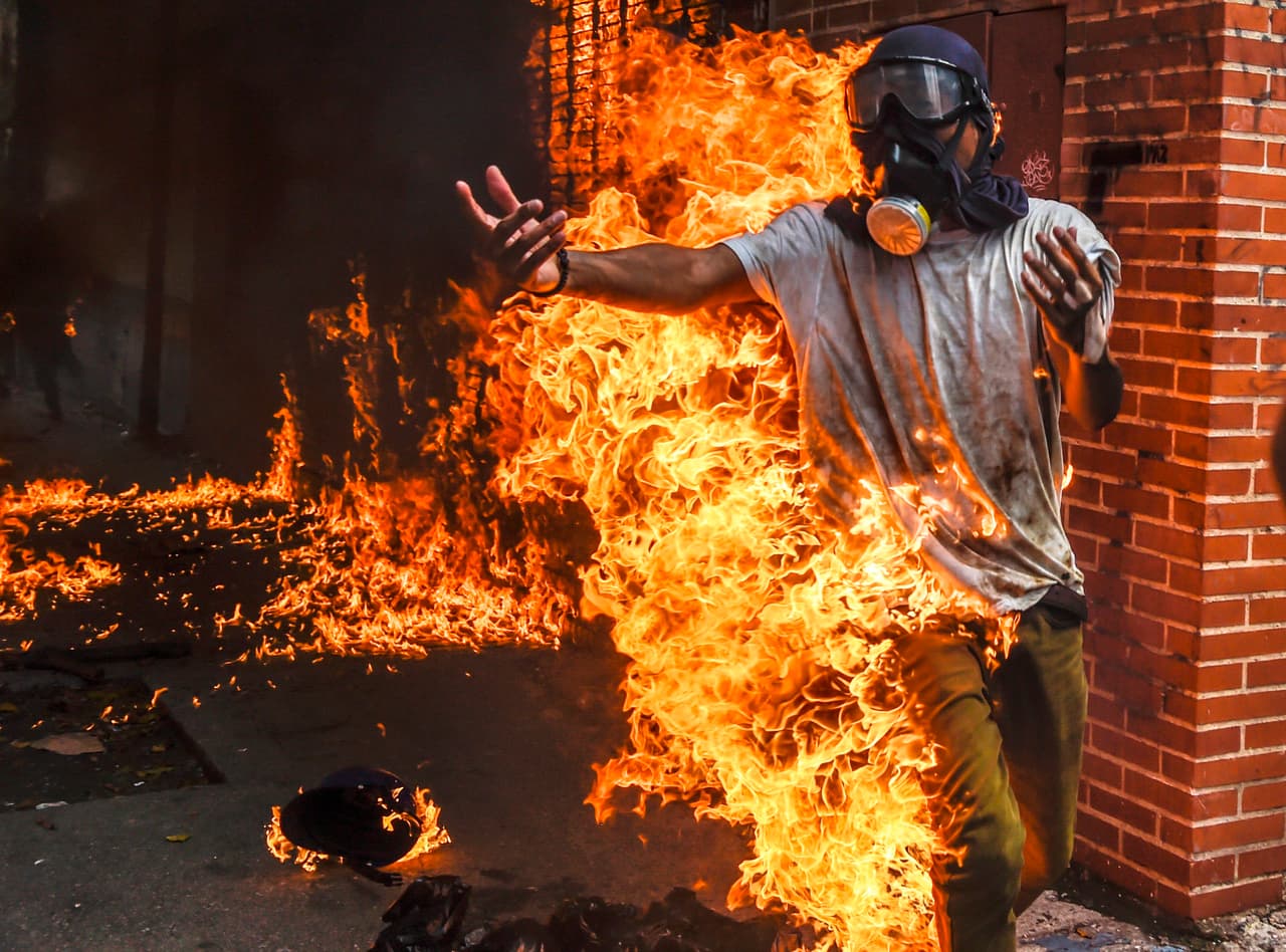 <b>La crisis venezolana.</b> Las protestas callejeras contra el gobierno de Nicolás Maduro dejaron más de un centenar de muertos. 
<b><a href="https://www.univision.com/noticias/crisis-en-venezuela/46-muertos-en-43-dias-el-rastro-de-sangre-de-las-protestas-en-venezuela">La cruel represión de las fuerzas policiales y militares de Maduro apaciguaron las calles</a></b> de un país con una indetenible crisis económica y gobernado por un régimen dictatorial, según EEUU y la OEA. En la foto, un manifestante opositor al gobierno se prendió en fuego accidentalmente cuando intentaba incendiar la motocicleta de un policía en Caracas. 3 de mayo de 2017.