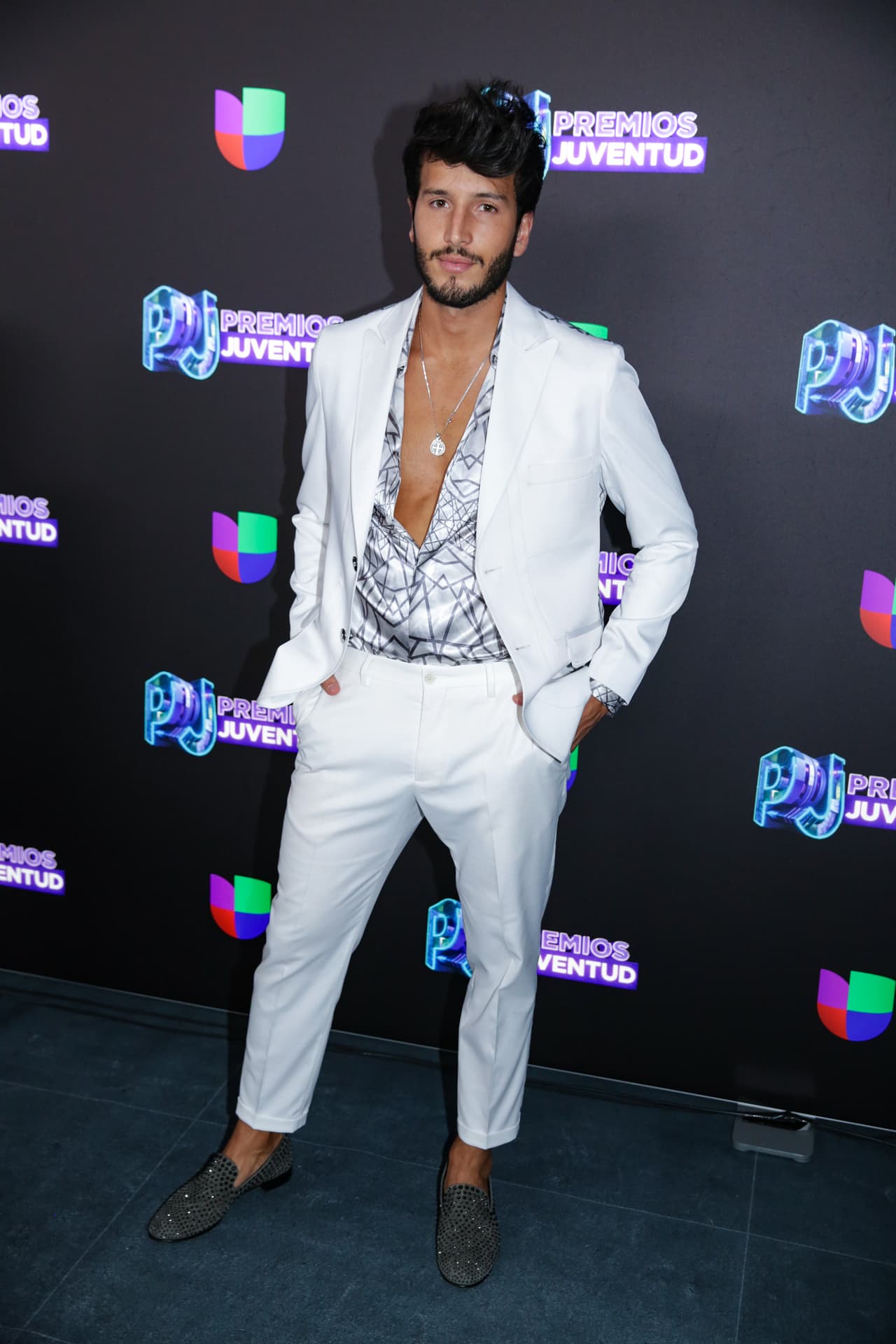 Muy en tendencia vimos a Sebastián Yatra, con este traje blanco y camisa plateada entre abierta. Los zapatos sin calcetines le fueron muy bien al conjunto.