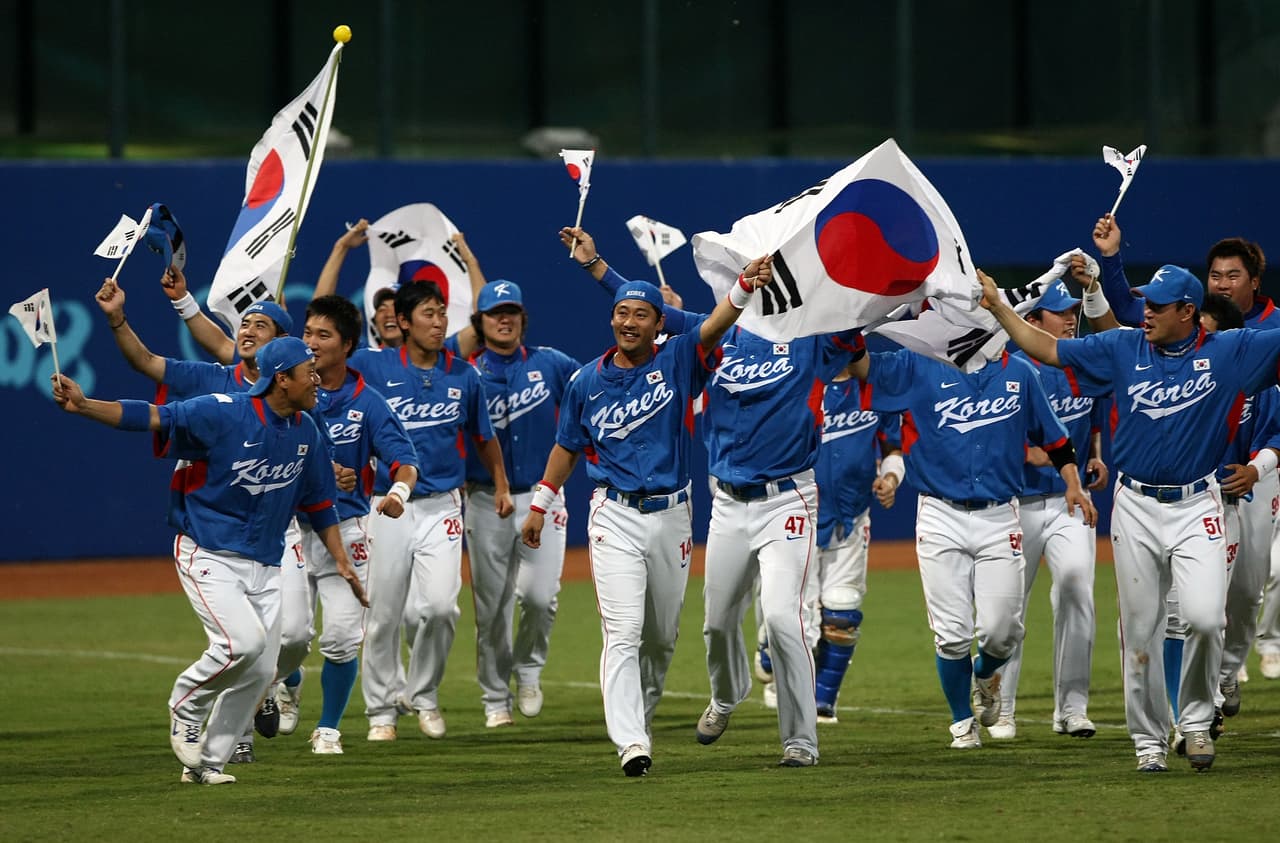 BEIJING - AUGUST 23: Players from Korea take a lap around the outfield as they celebrate their 3-2 win against Cuba during the men's gold medal baseball game held at Wukesong Baseball Field on Day 15 of the Beijing 2008 Olympic Games on August 23, 2008 in Beijing, China. (Photo by Jonathan Ferrey/Getty Images)