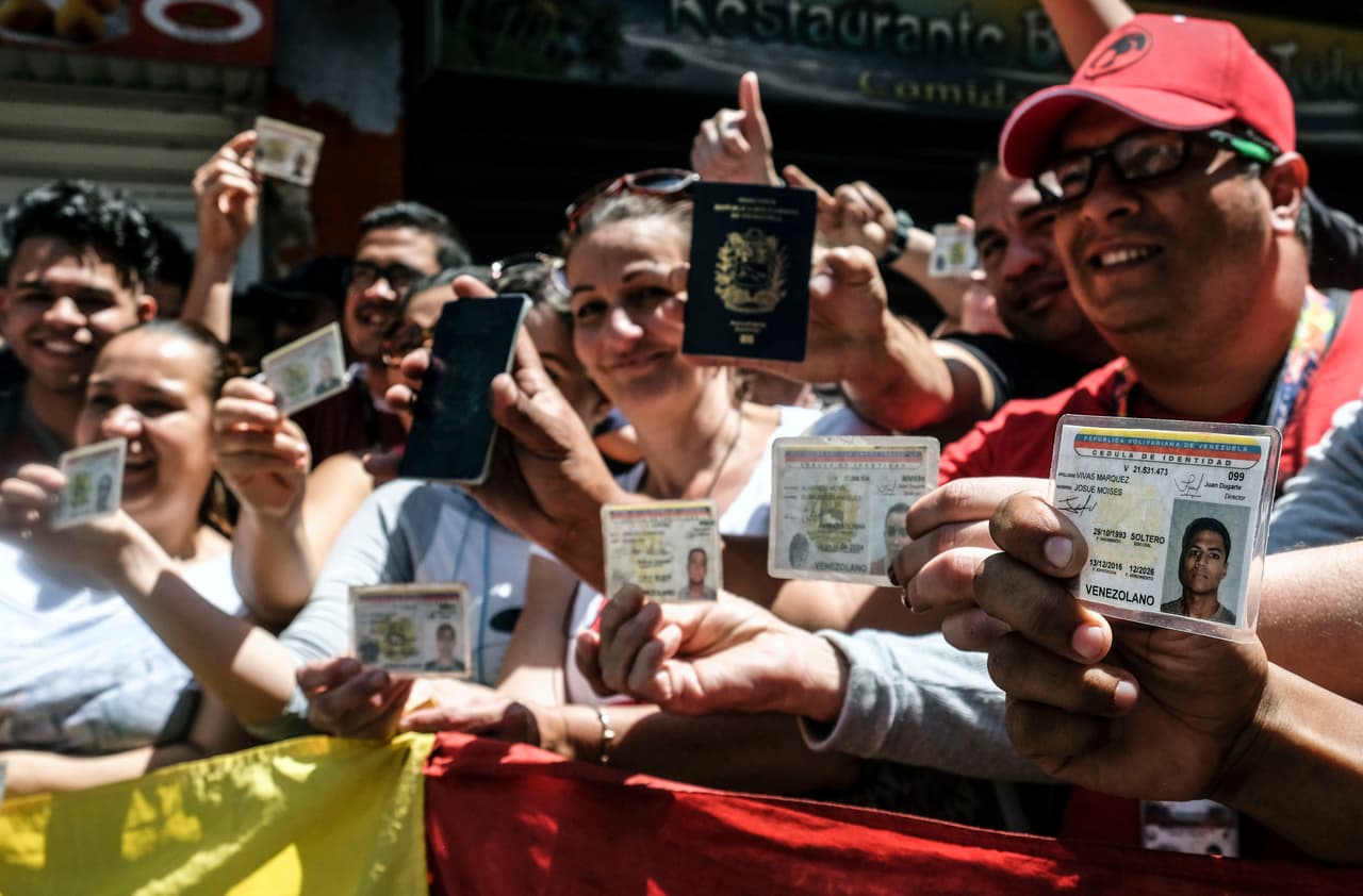 Voters In Bogota show off their Venezuelan documents.
