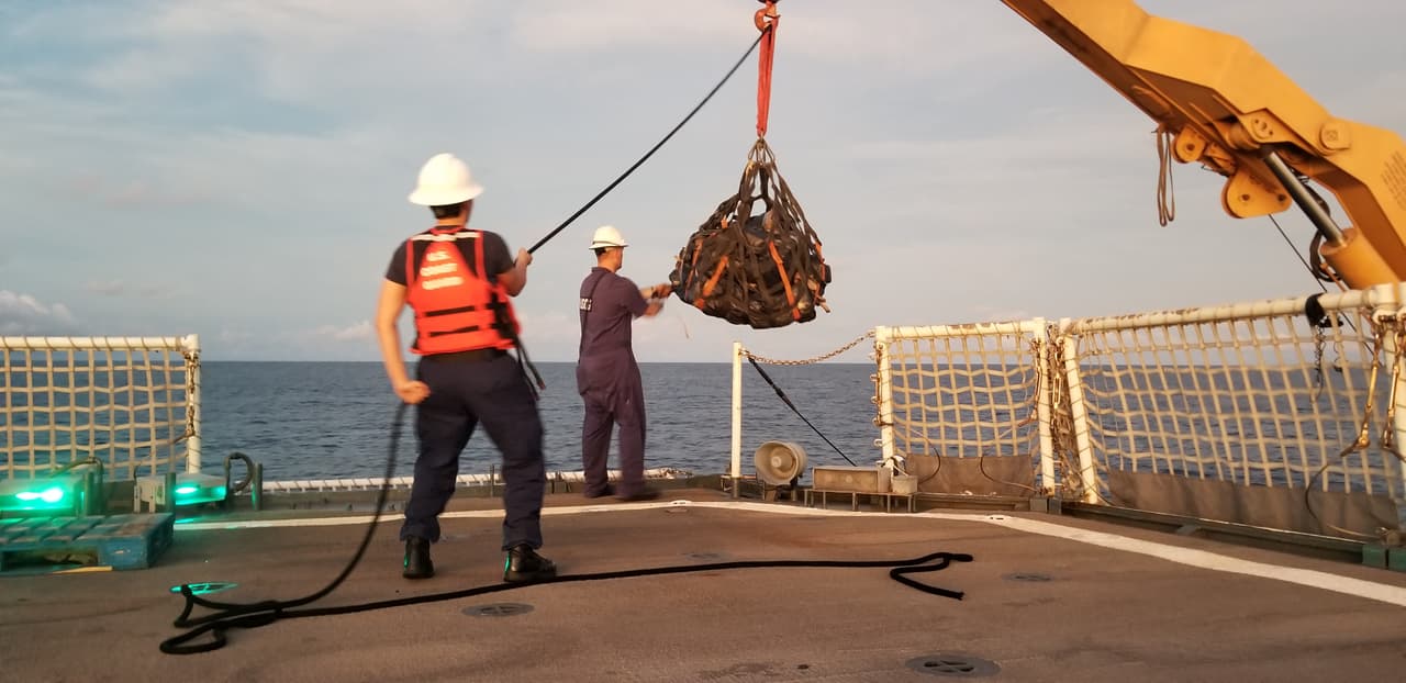 Una vez que han sacado los paquetes con droga de los narco sumergibles, los oficiales lo llevan al buque de la Guardia Costera.