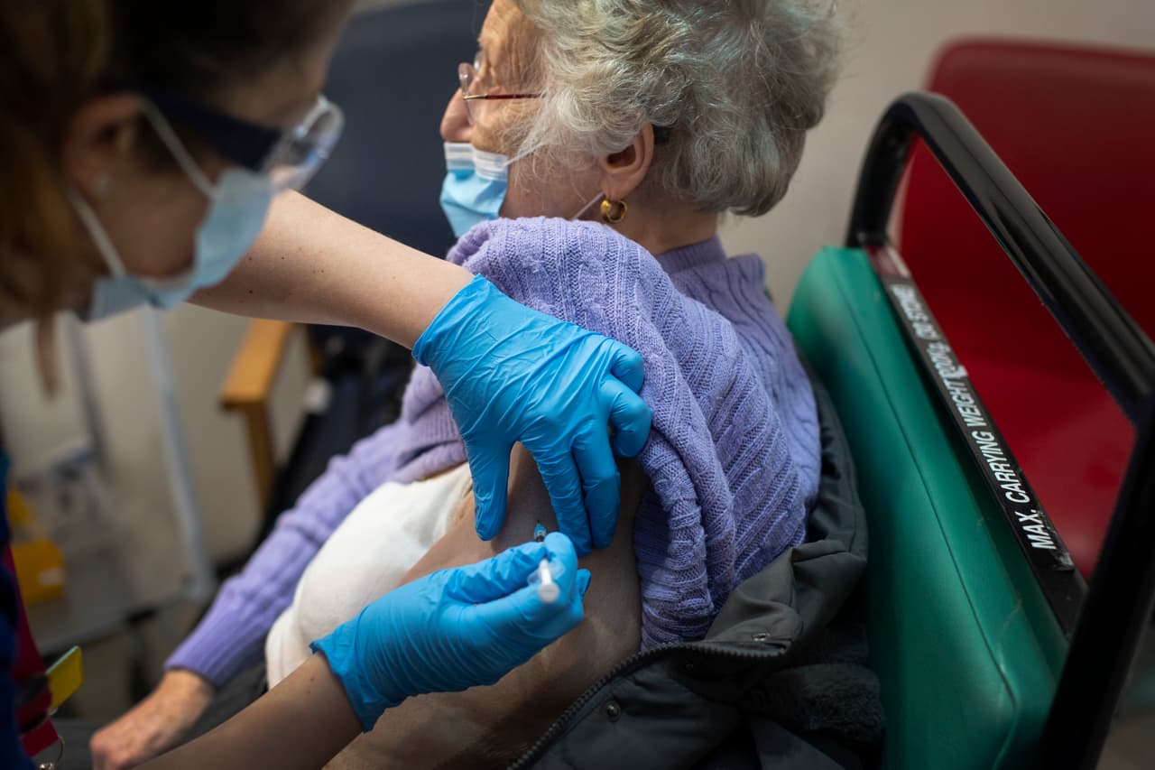Una mujer al recibir la vacuna en un hospital de Londres. El personal médico contactará a los pacientes para organizar las citas y la mayoría tendrá que esperar al año que viene, hasta que haya suficientes vacunas para ampliar el programa.
<br>