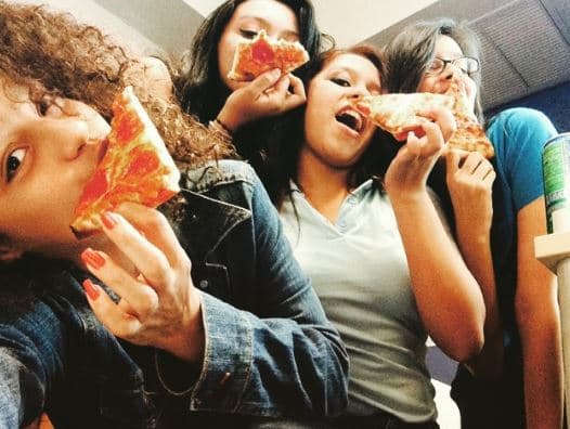 Alondra disfruta comiéndose un buen pedazo de pizza.