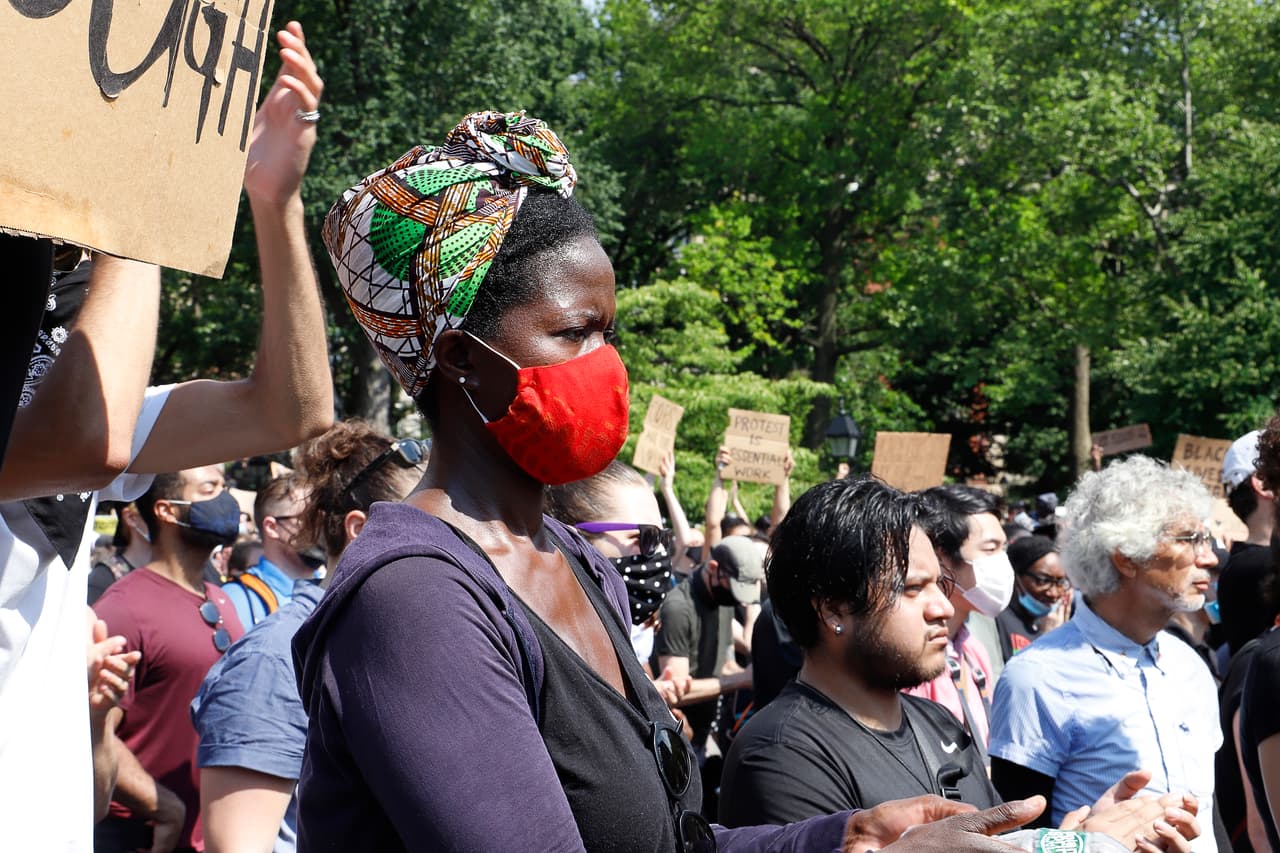 Madre afroamericana en compañía de su hijo acude a masiva protesta en el Washington Square Park de Manhattan.