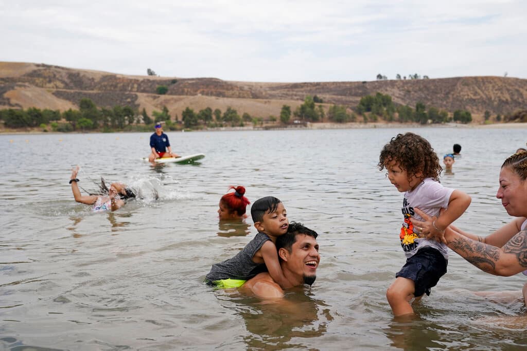 Esta familia optó por bañarse de un río para huir del calor en Castaic, California, este jueves, cuando ya se sentían los primeros embates del alza de las temperaturas.