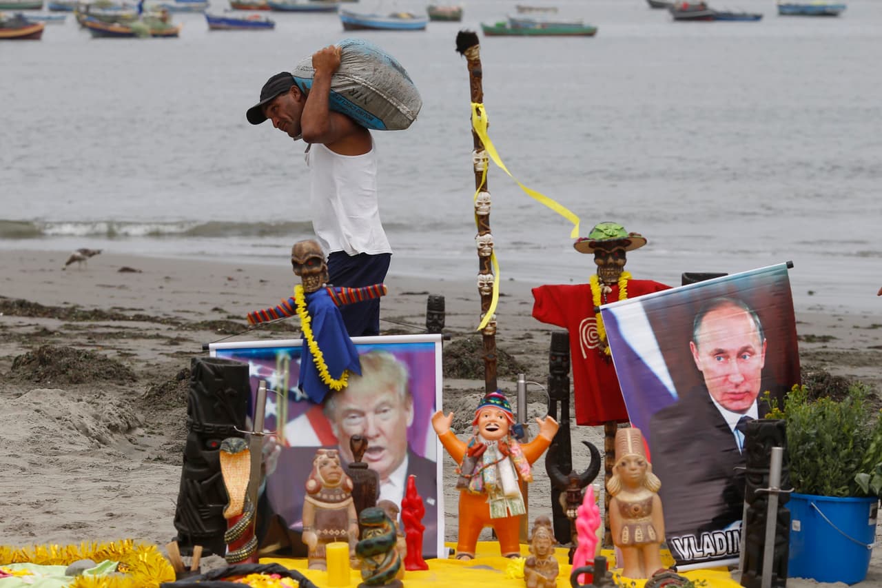 LIMA, PERÚ.-
<b>Trump. Putin. Calamidades. </b>En la imagen, un pescador pasa por delante de un altar con imágenes de Donald Trump y Vladimir Putin, creado por un grupo de chamanes para su ceremonia anual de preaño nuevo, en la playa Agua Dulce. Según reporta AP, los chamanes que realizaron su ritual en la playa, advirtieron que sus visiones para 2017 estaban llenas de calamidades, incluyendo más ataques terroristas en toda Europa y un colapso total de la economía mundial.