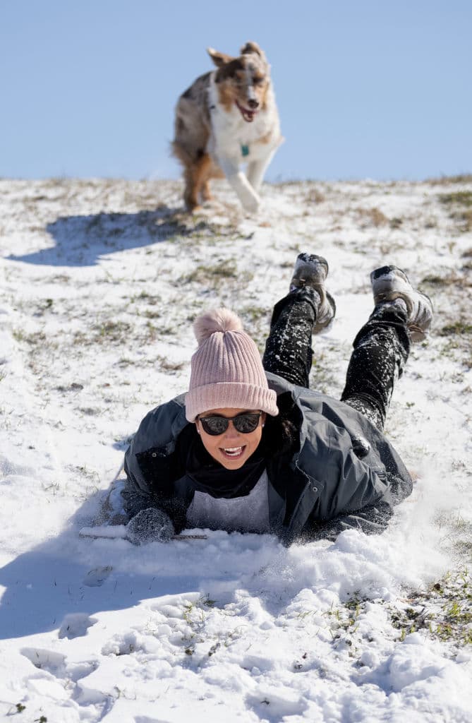 El mal tiempo hizo que alrededor de un tercio del país registrara temperaturas bajo cero el lunes, 
<a href="https://edition.cnn.com/2021/02/15/weather/winter-storms-weather-monday/index.html" target="_blank">de acuerdo con un reporte de CNN</a>. En la imagen, una mujer juega en la nieve con su perro en Fort Worth, Texas.