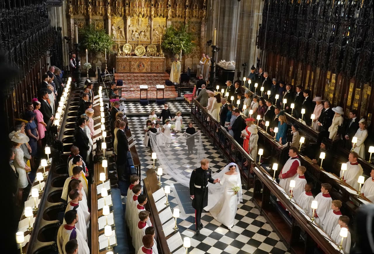 El príncipe Harry y Meghan Markle abandonan la capilla de San Jorge. Junto al altar solamente un grupo selecto de invitados, principalmente la familia real y algunos parientes de la novia, pudieron ver la ceremonia. El resto de los asientos estaban ocupados por el coro de niños.