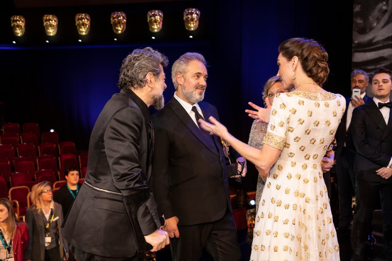 La madre de 
<b><a href="https://www.univision.com/famosos/las-fotos-que-muestran-a-los-principes-george-charlotte-y-louis-robandose-algo-del-primer-show-de-su-primo-archie-fotos">los príncipes George, Charlotte y Louis</a></b> intercambió impresiones con el laureado director Sam Mendes y también con Joaquin Phoenix, el 'Joker'.