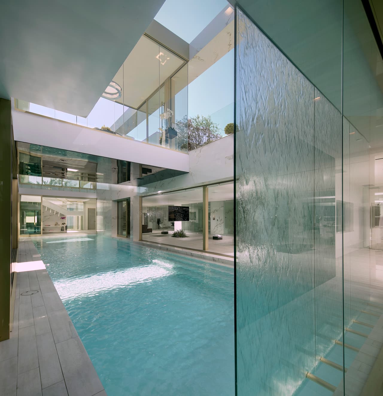 Una de las piscinas cuenta con una cascada de 20 pies de altura sobre un pared de cristal.