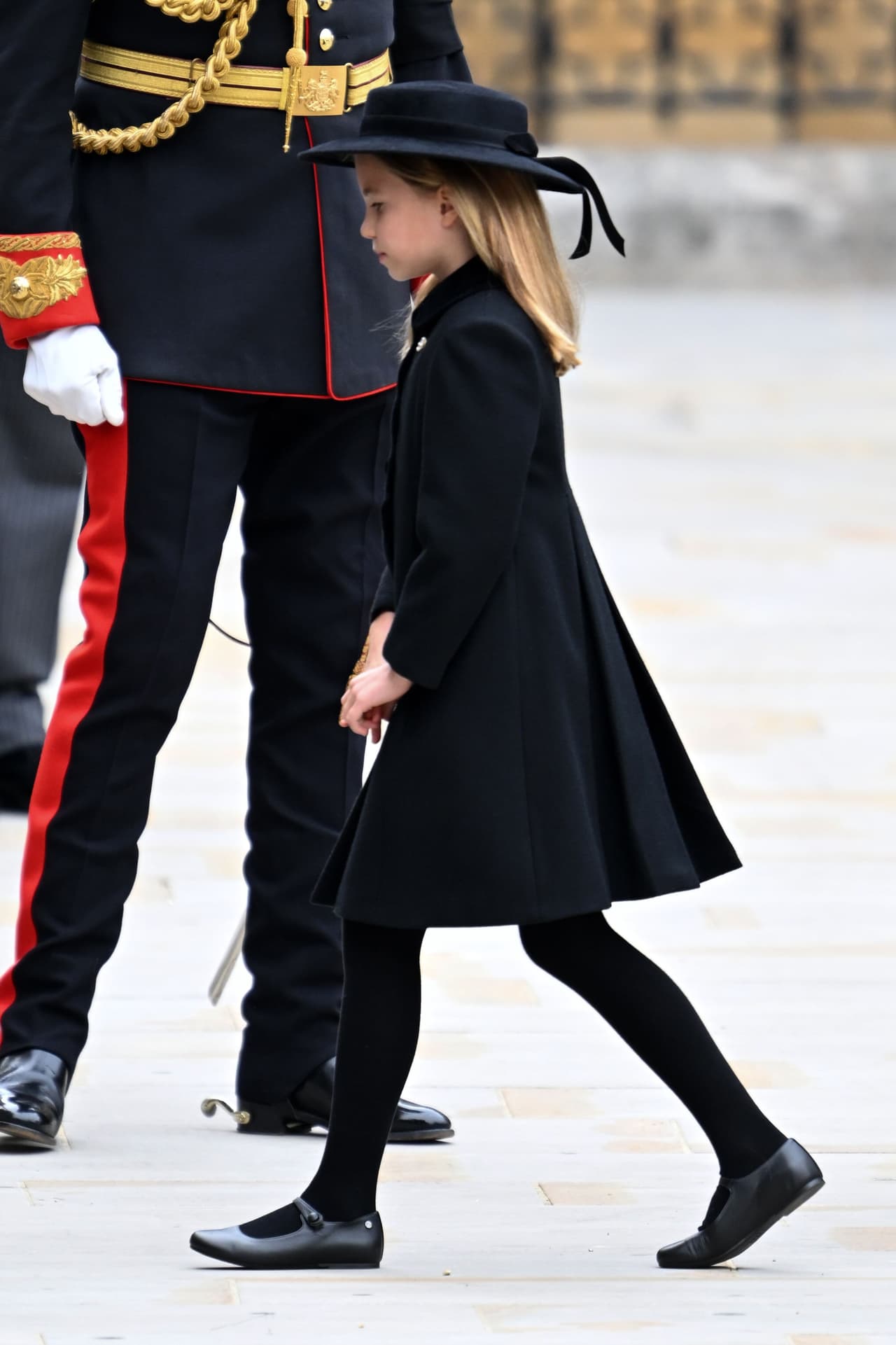 La niña usó un sombrero negro con un lazo y un abrigo de terciopelo. 
<br>