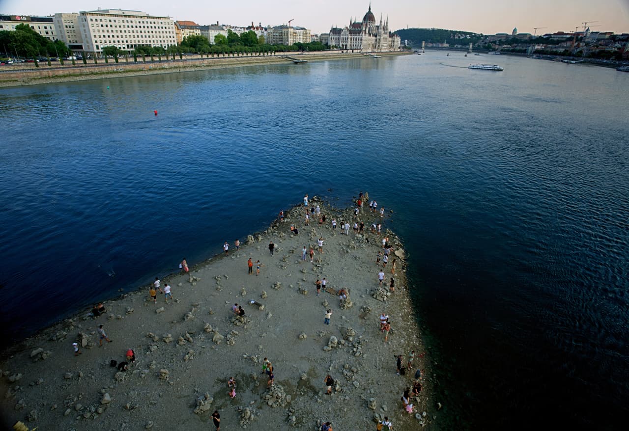 Unas personas caminan por un banco de arena bajo el puente Margarita del Danubio, en el centro de Budapest (Hungría), el miércoles 5 de agosto de 2026, mientras el río —que atraviesa diez países europeos— ha descendido a niveles de caudal nunca vistos.