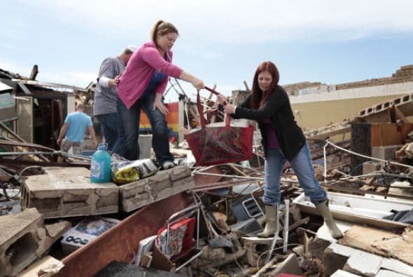 Amber Ford y la maestra Sheri Bittle recuperan artículos del salón en el que daban clase en la Escuela elemental Briarwood, en Moore.