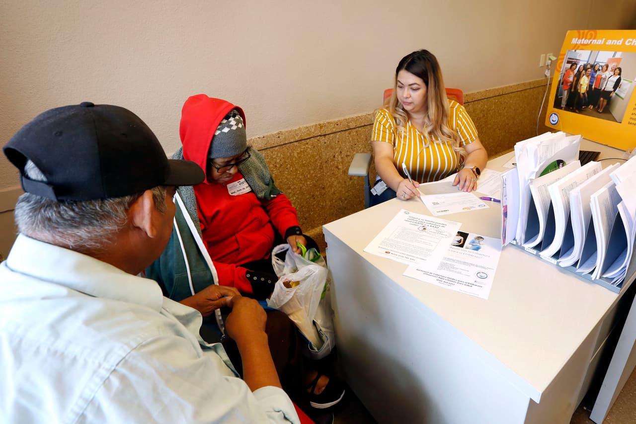 06/26/19/LOS ANGELES/Health care navigator Marylia Ruano (R), from Maternal and Child Health Access, assists clients at their USC satellite office. (Aurelia Ventura/La Opinion)