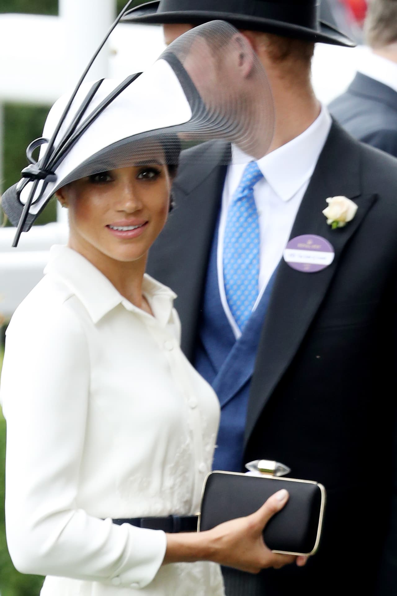 <b>19 de junio, 2018. </b>Como las reglas de Ascot cambiaron y se prohibió el uso de ‘fascinators’, Meghan lució una espectacular pamela en paja estructurada de 
<b><a href="https://www.philiptreacy.co.uk/en/collection/ss18/OC-423">Philip Treacy</a></b> en blanco y negro con 
<b><a href="https://goldcoastcouture.com/new-proportion-lace-wave-black-and-multi/">bordes ondulados</a></b> y detalles de 
<b><a href="https://www.harrods.com/en-gb/philip-treacy/two-tone-oval-headpiece-p000000000005874778?bcid=1468510895325">nudos</a></b> que usó Meghan fue perfecta para la ocasión.