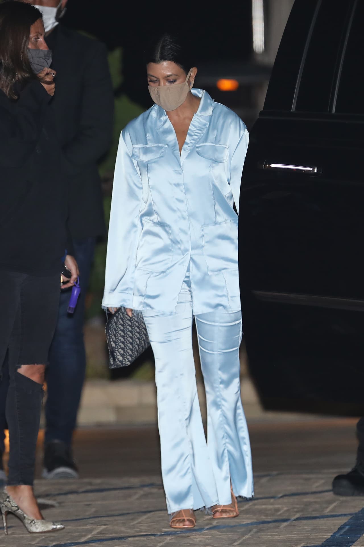 Acompañó su traje con unas sandalias Bottega Veneta con cintas color naranja, que hicieron juego con la mascarilla con la que salió de casa esa noche. Complementó su look con un bolso Christian Dior.