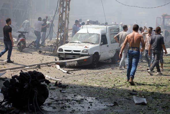 Lebanese citizens gather outside al-Salam mosque, near the house of former Lebanese police chief Ashraf Rifi, at the site of a powerful explosion in the northern Le