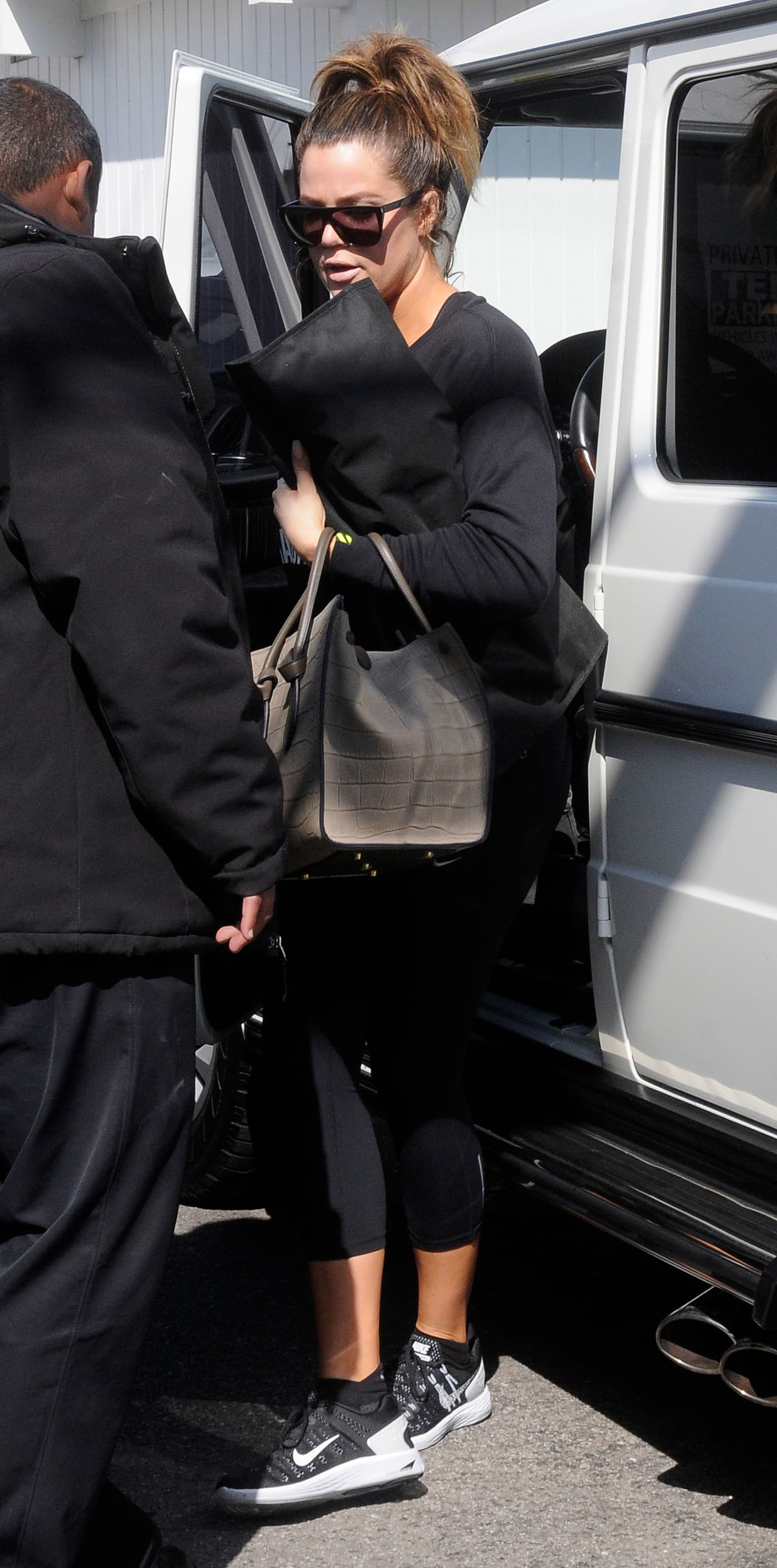 ¿Quieres algo muy Kardashian? Mira cómo viste Khloe: sudadera y leggins negros con pantalones deportivos casi al tobillo.