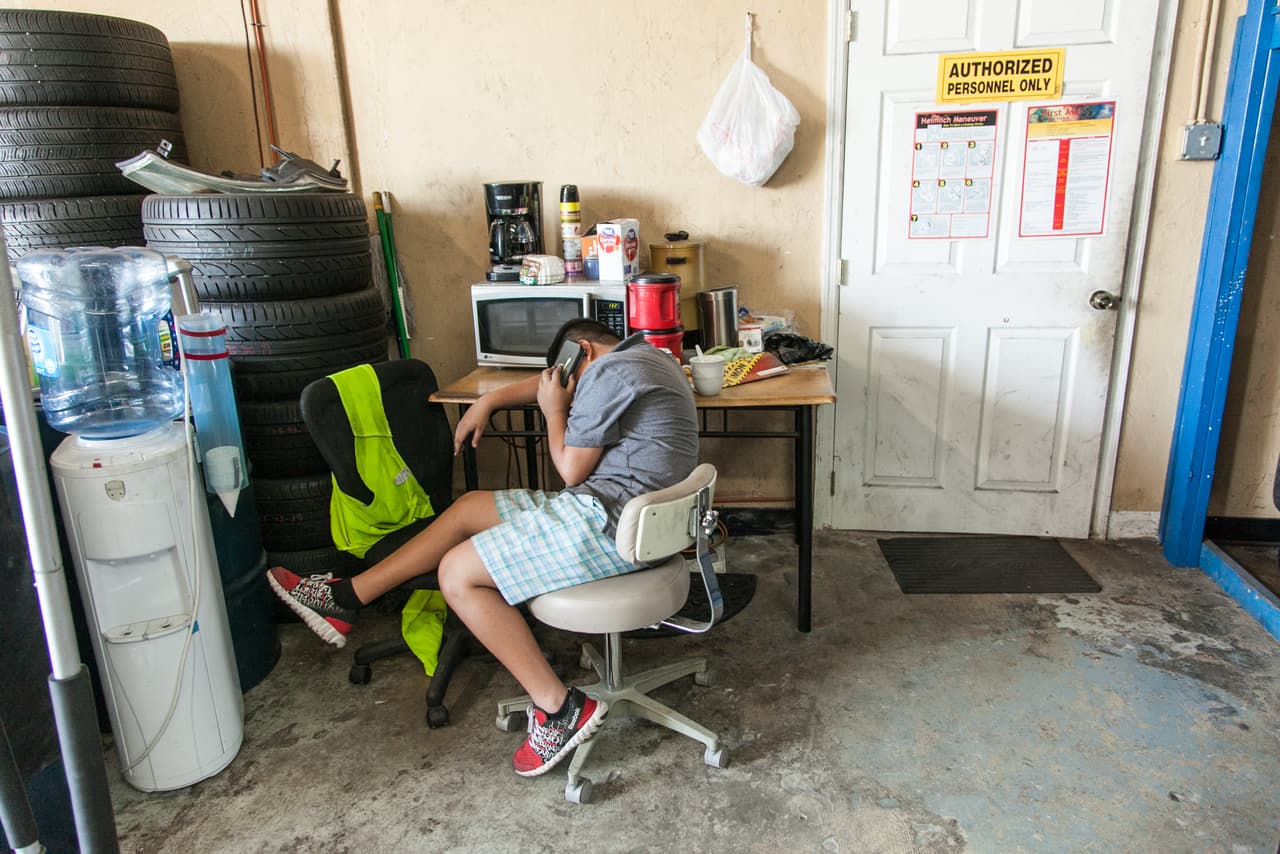 Desde el centro de detención, Víctor llama cada día a su familia. En la imagen, el momento en que su hijo
<b> </b>Jimmy habla con él desde el taller. “Yo también te quiero", le dice antes de colgar.