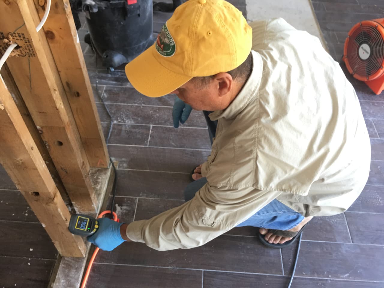 Javier Ramírez, un residente de Canyon Gate en Katy afectado por las inundaciones, usa un sensor para medir el porcentaje de humedad en la madera que va al interior de las paredes de su casa.