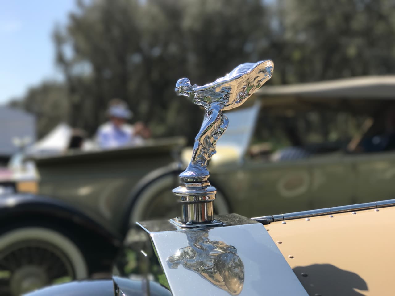 Ninguna colección fotográfica de adornos de capó estará completa sin mostrar a esta dama alada, mejor conocida como el 'Espíritu del Éxtasis', la eterna mascota de los vehículos de Rolls-Royce la más reconocida marca de autos de lujo de todos los tiempos. En este ejemplo en partícular, el Espíritu del Éxtasis está parado sobre la parilla de rayos verticales de un
<b>Rolls-Royce Picadilly Roadster de 1925</b>.