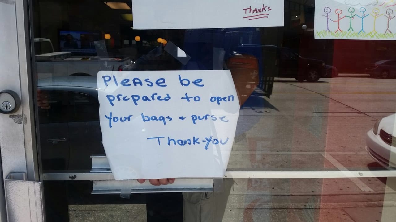 "Por favor prepárese para abrir sus mochilas y carteras. Gracias", dice este cartel frente a The Center en Orlando.