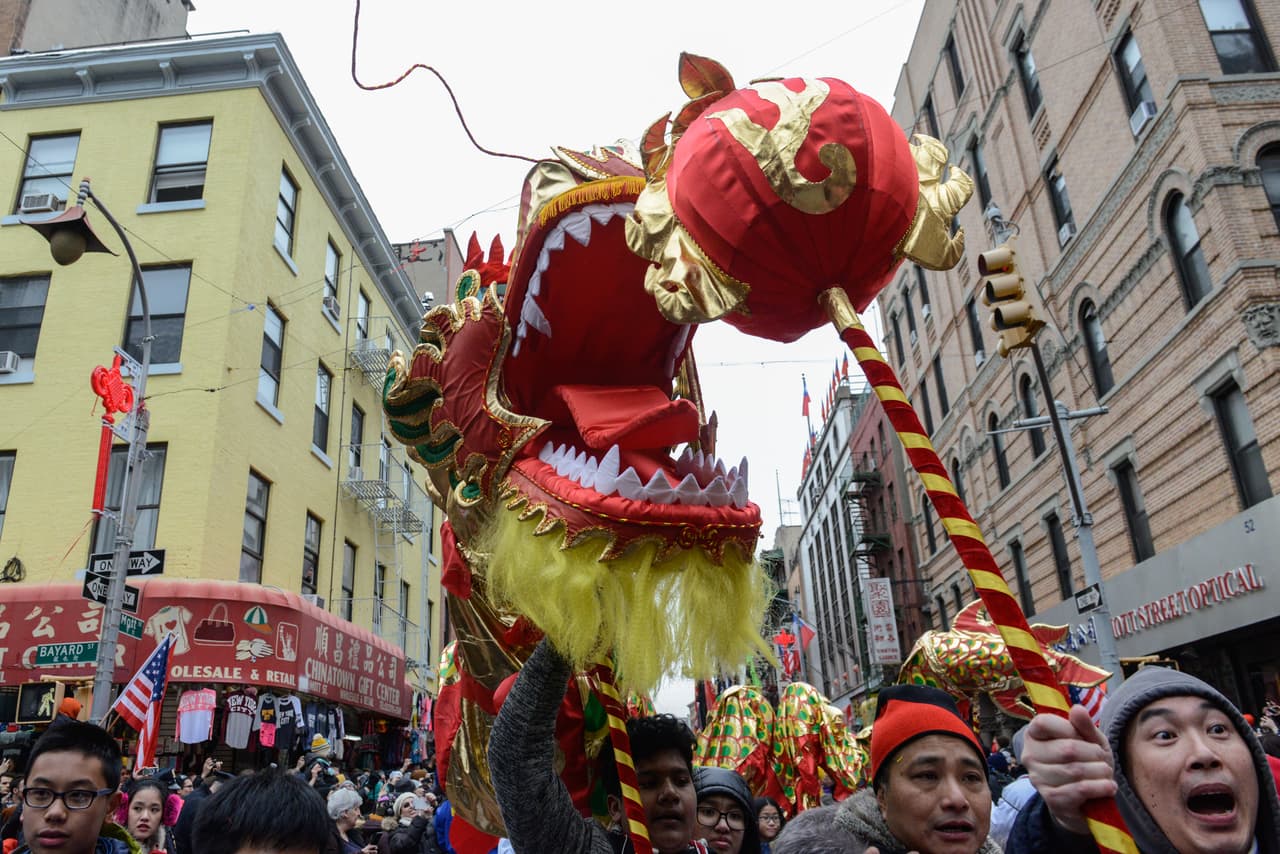 La gente lleva una decoración tradicional del dragón durante el desfile lunar chino del Año Nuevo en Chinatown, en New York City.