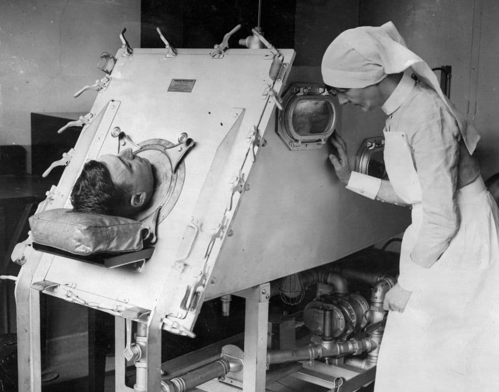 30th July 1938: A patient in an Iron Lung being checked by a nurse. (Photo by Keystone/Getty Images)