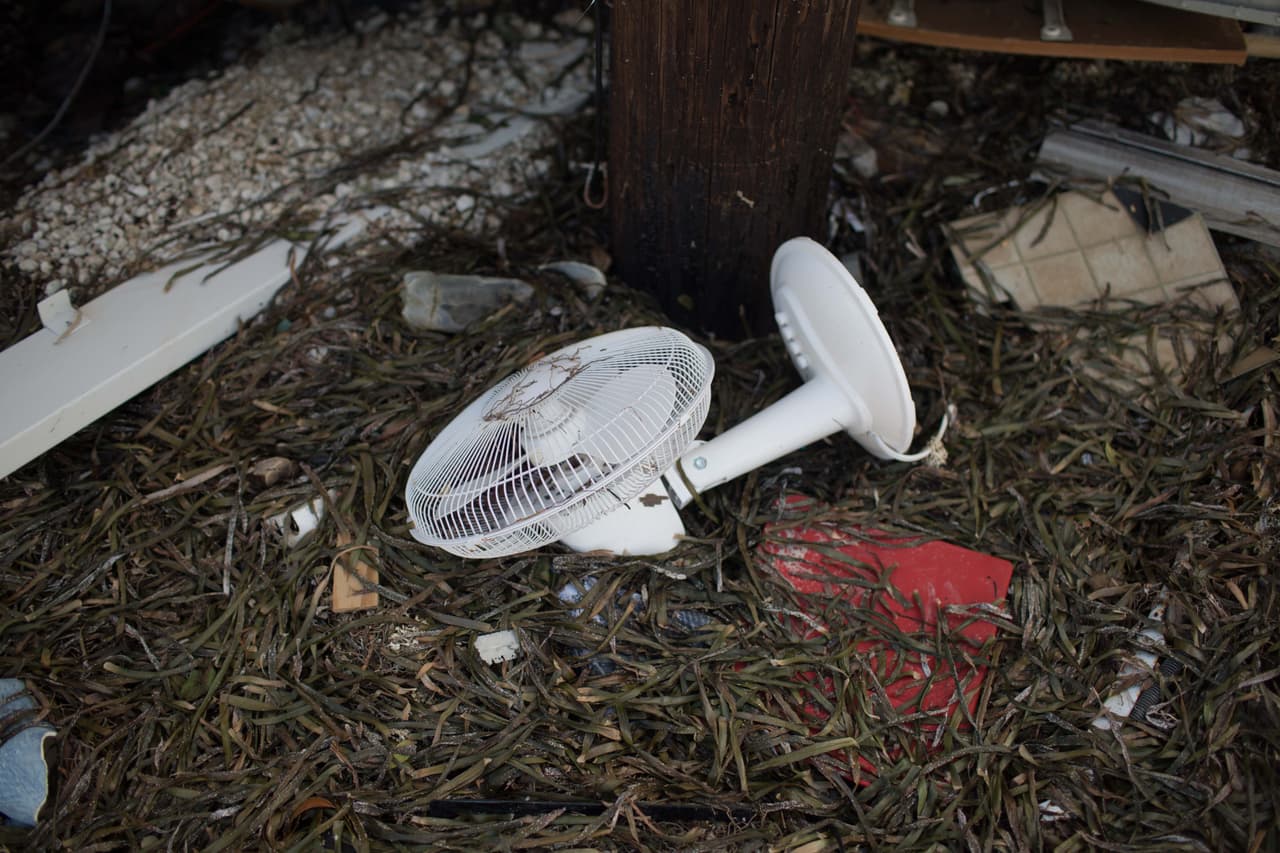 Un ventilador tumbado cerca del océano y de varias casas destruídas. Almudena Toral/Univision Digital