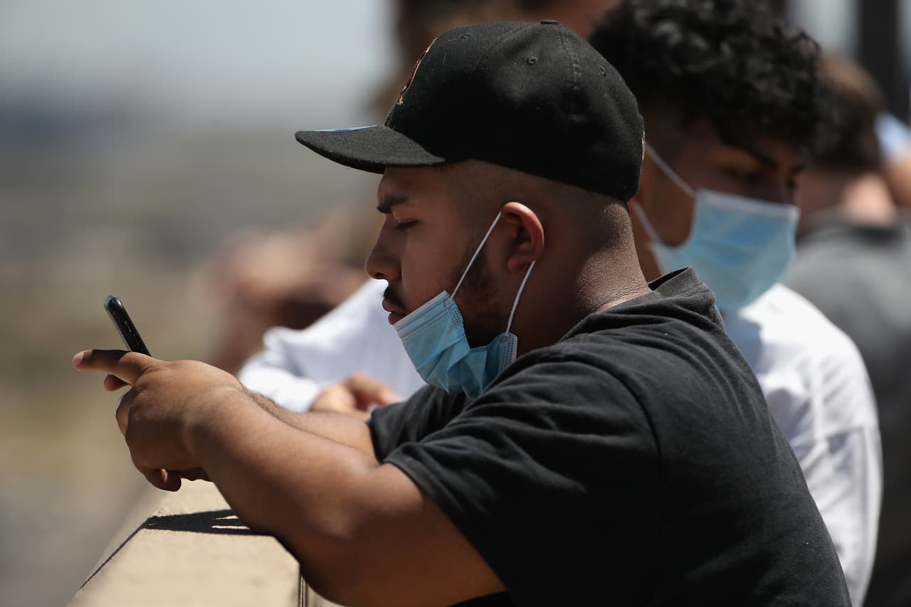 Espectadores con máscaras faciales, esperan el aterrizaje del Air Force One en el aeropuerto Sky Harbor en Phoenix, Arizona. El presidente Donald Trump visita la fabrica Honeywell que fabricará máscaras N-95.