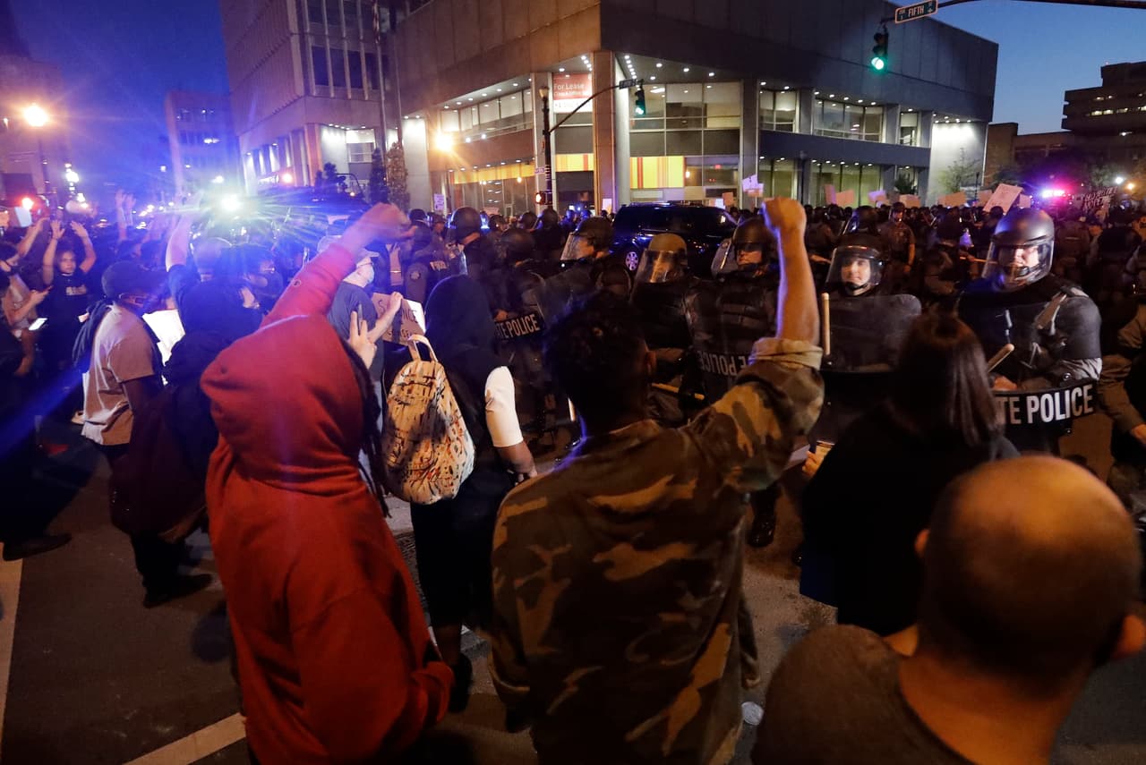 En Louisville, Kentucky, manifestantes gritan frente a los agentes de la Policía Estatal.