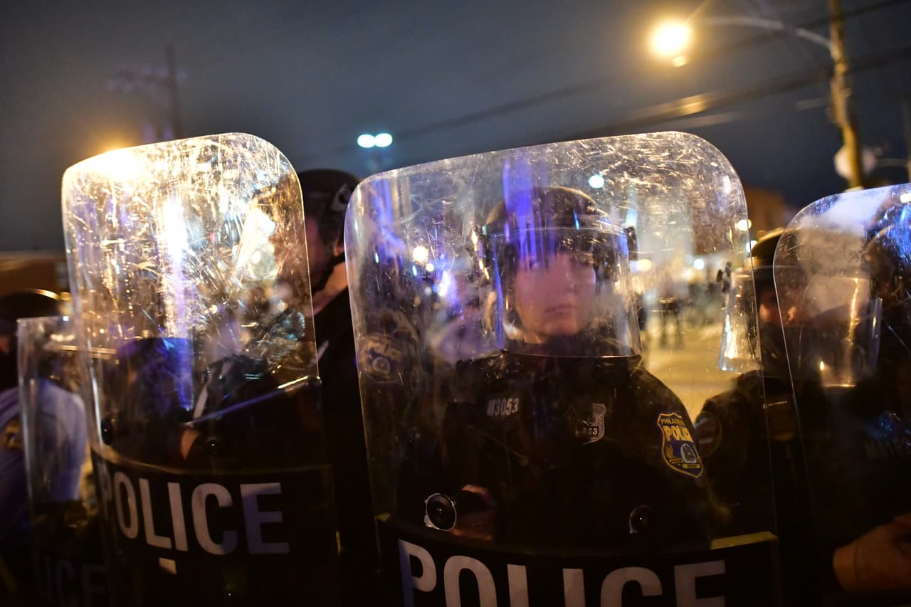 La policía con equipo táctico forma una línea frente a los manifestantes. Varios oficiales de la uniformada resultaron heridos.