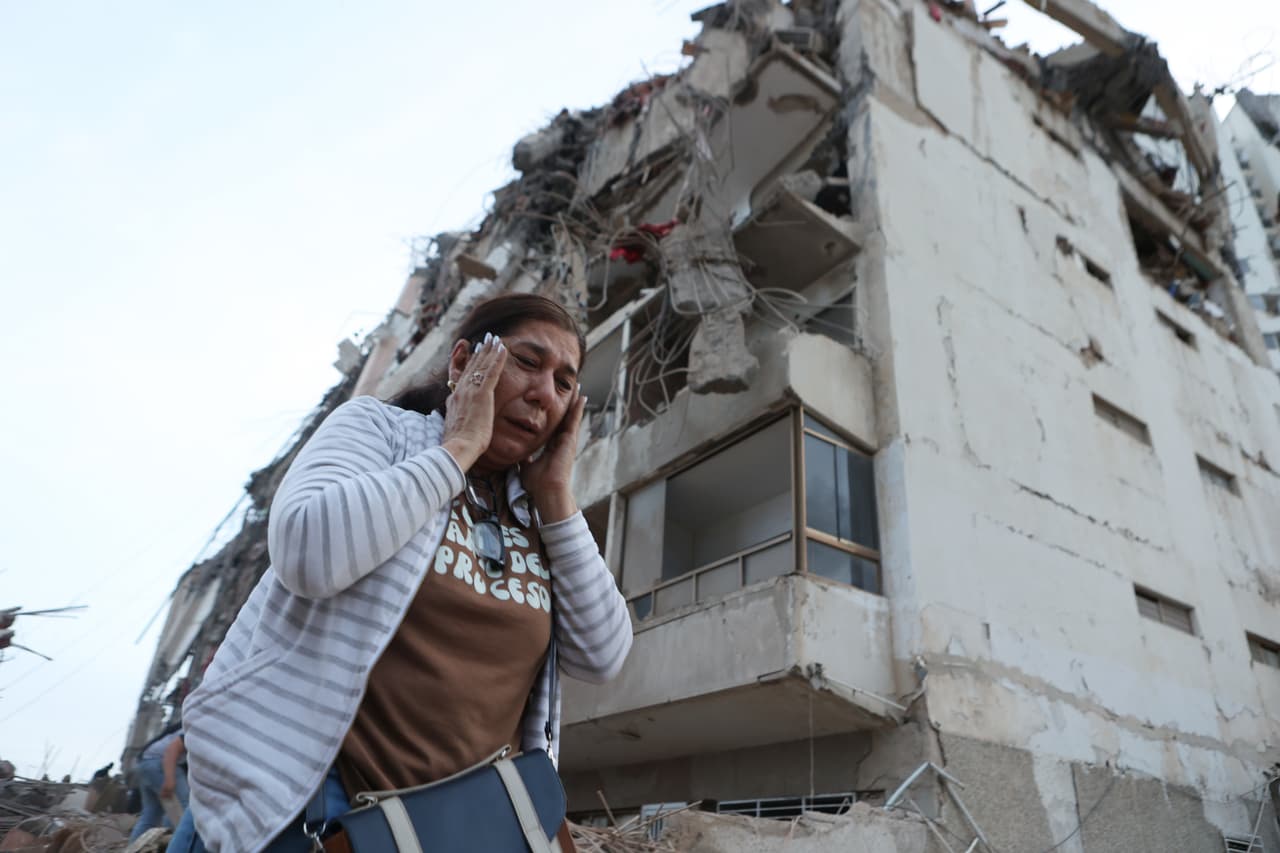 Una mujer pasa junto a un edificio dañado durante un terremoto en La Guaira, Venezuela, el jueves 25 de junio de 2026.