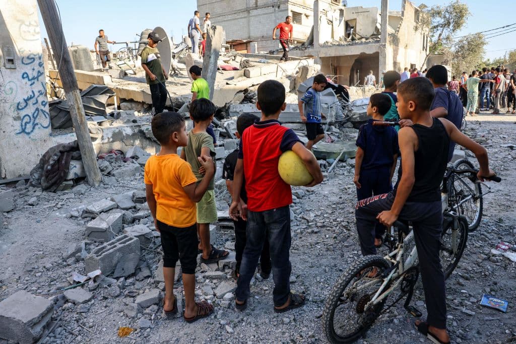 Niños en Gaza miran un edificio destruido por un bombardeo de Israel.