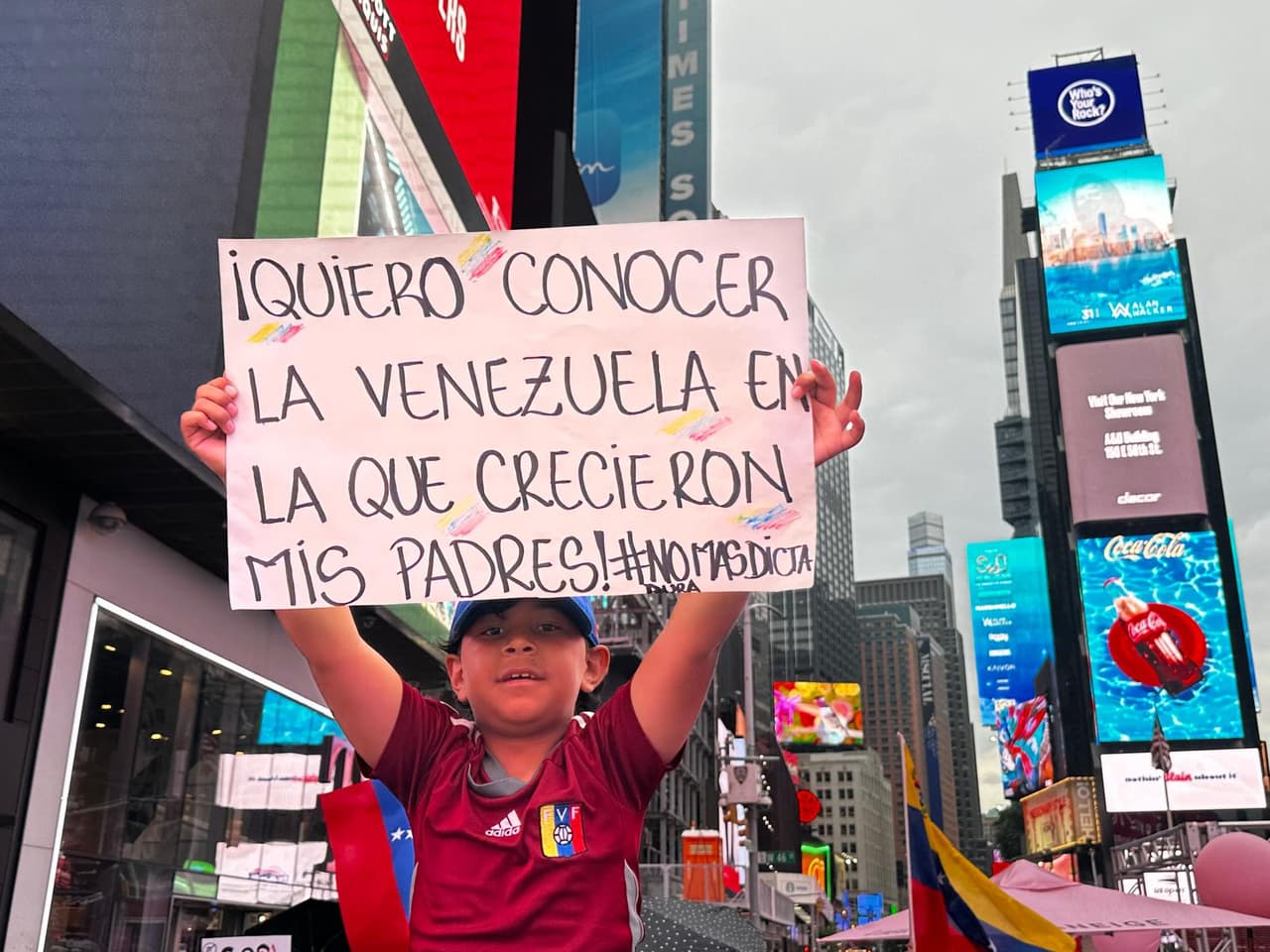 "Quiero conocer la Venezuela en la que crecieron mis padres" dice el cartel sostenido por un niño con la camiseta de la selección nacional de fútbol.