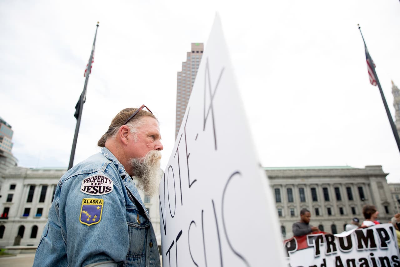 “Vota por Jesús”, se lee en el cartel de este manifestante, frente al centro de convenciones.
