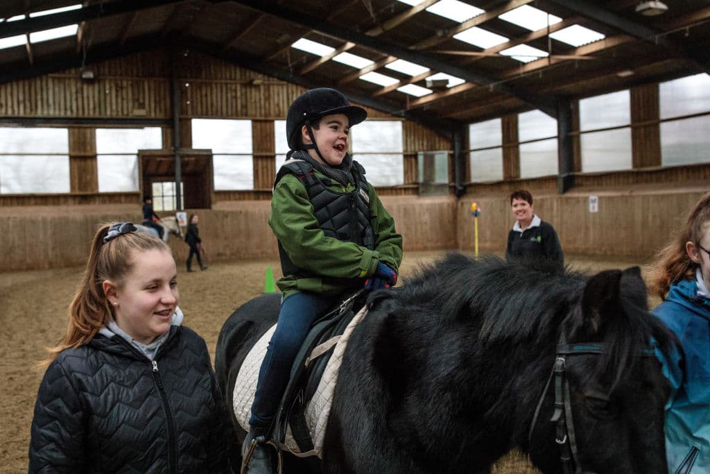 Alfie recibe lecciones para montar a caballo. El tratamiento con cannabis medicinal le permite disfrutar de actividades como montar a caballo o en bicicleta.