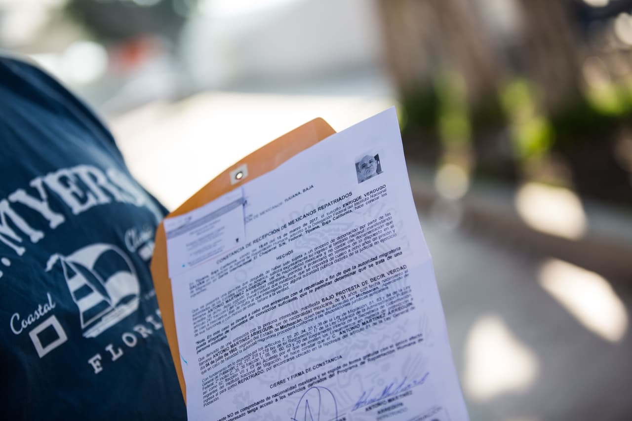 Uno de los deportados, Antonio Martínez-Arreguín, muestra su “constancia de recepción de mexicanos repatriados” cerca de El Chaparral, antes de emprender la caminata de horas para intentar llegar a casa de un primo. La constancia le sirve, hasta que pueda tramitar sus documentos, para identificarse como ciudadano de México. No tiene dinero, teléfono ni documentos. Almudena Toral/Univision Digital
<br> 
<br>