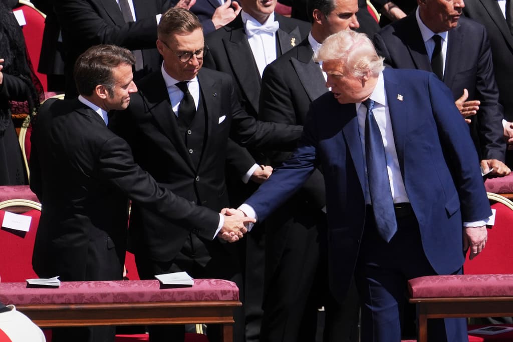 El presidente Donald Trump también participó, acompañado de su esposa Melania. En la imagen, se da la mano con su par francés, Emmanuel Macron, en un momento clave en el que los líderes mundiales mantienen conversaciones en búsqueda del fin de la guerra en Ucrania.
