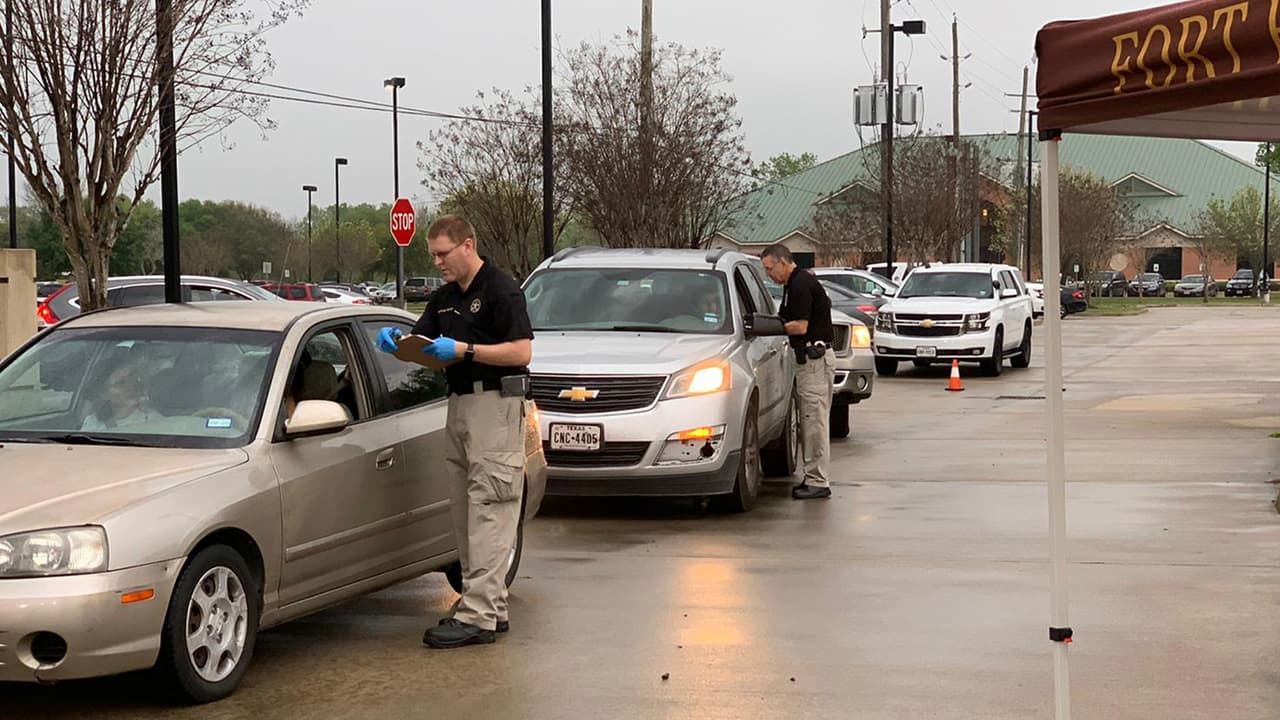 Los residentes reciben de manera gratuita botellas de solución para desinfectar superficies. Esta acción fue organizada por la oficina del Sheriff del condado Fort Bend, en colaboración con la Oficina de Manejo de Emergencias.