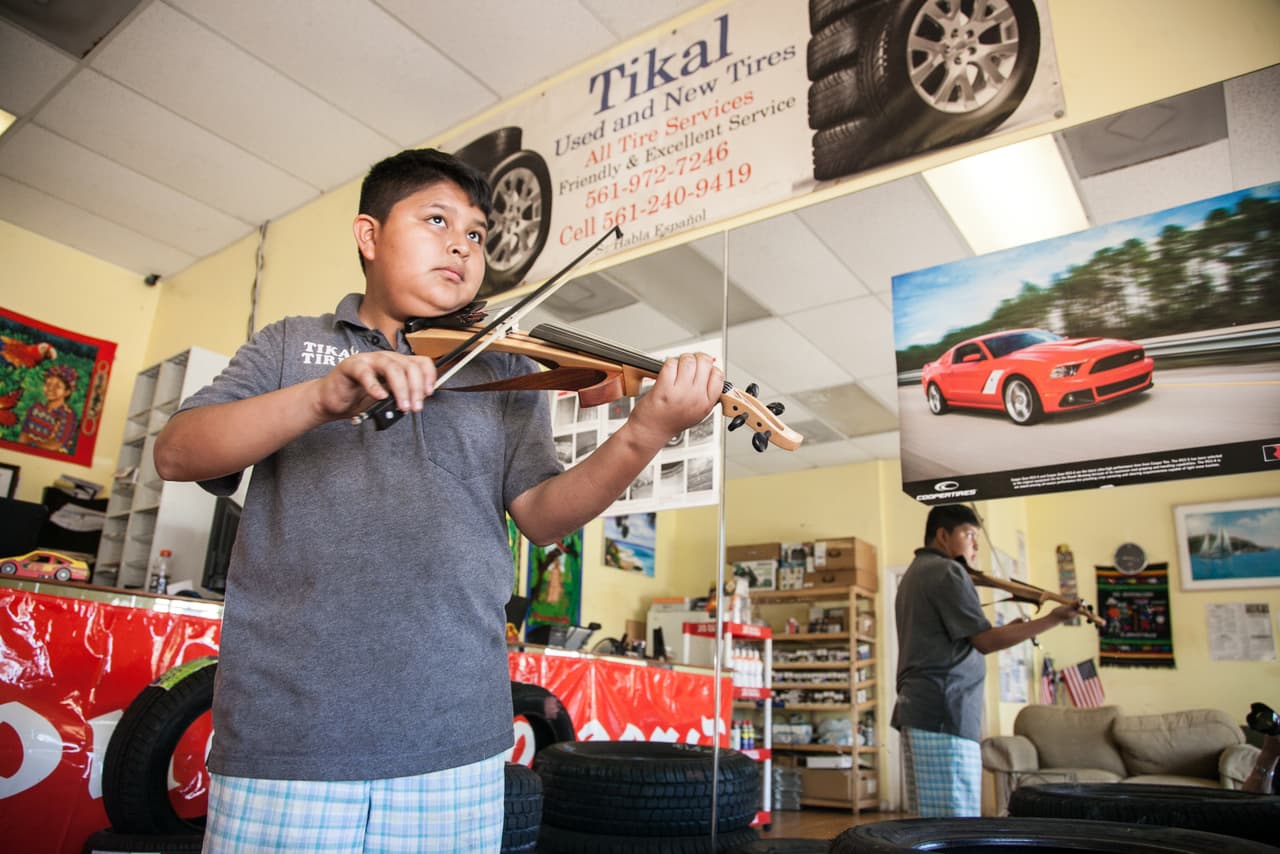 Jimmy es un buen estudiante que destaca principalmente en las materias de ciencias. El próximo curso debe empezar octavo grado y sueña con ser ingeniero biomédico. En la imagen, ensaya con su violín en la oficina del taller de sus papás.