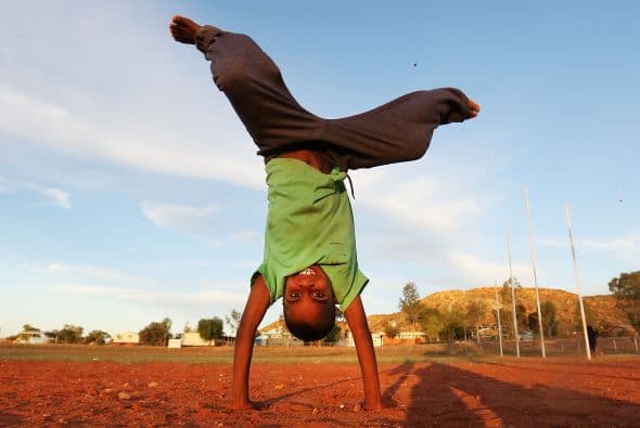 Un futbolista indígena se da una pirueta durante sus entrenamientos.