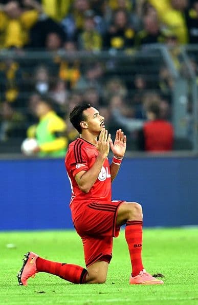 .El futbolista del Bayer Leverkusen Karim Bellarabi ora delante de los aficionados después del encuentro de la Bundesliga ante el Borussia Dortmund.