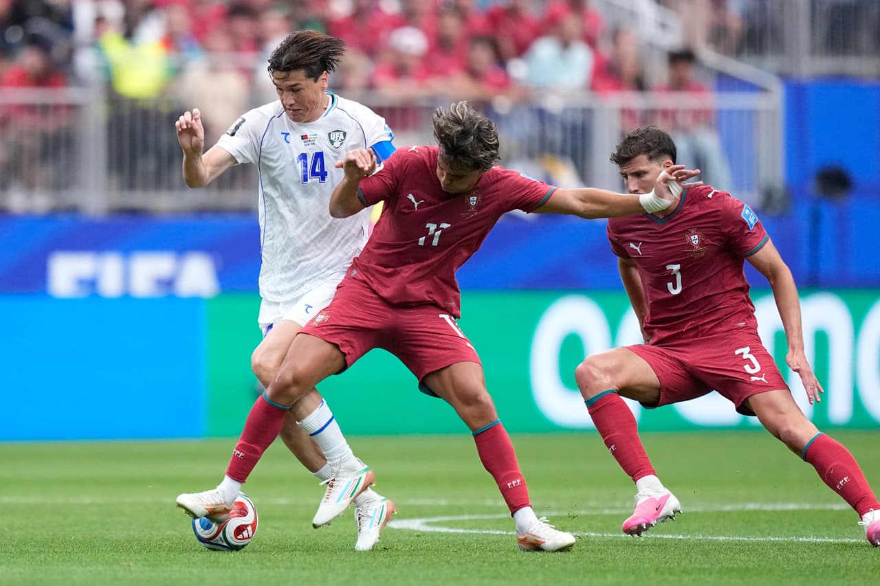 Eldor Shomurodov, de Uzbekistán (izquierda), disputa el balón con Joao Felix, de Portugal