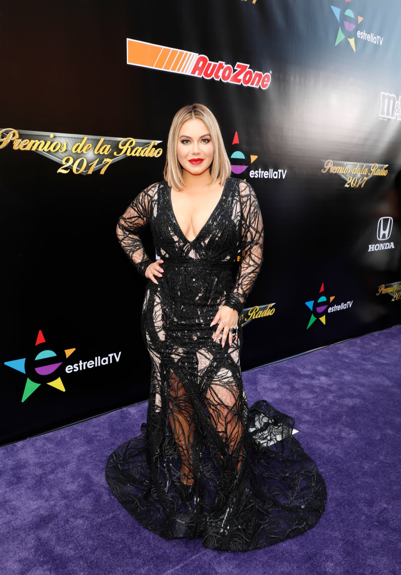 Para la alfombra morada de Premios de la Radio 2017, 'Chiquis' Rivera portó un elegante modelo del diseñador Walter Méndez, en negro, con mangas y piernas tipo red y una enorme cola.